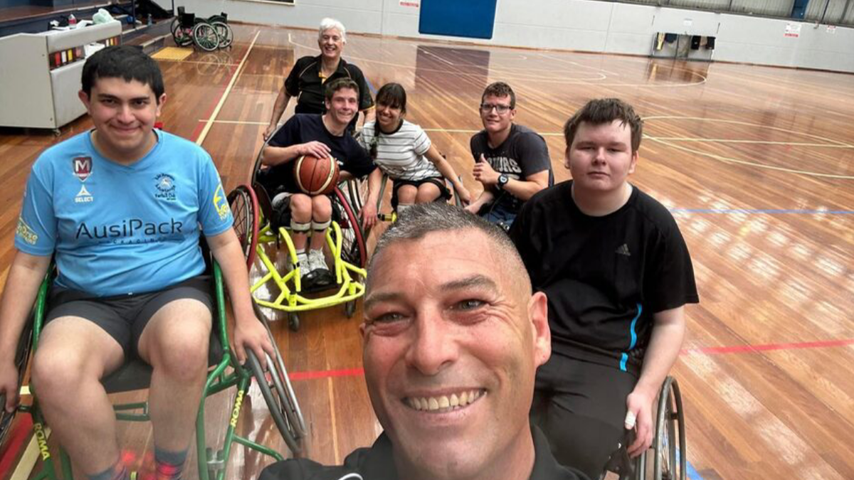 Players in specialized wheelchairs gather on the basketball court, showcasing the dynamic and inclusive sport of wheelchair basketball.