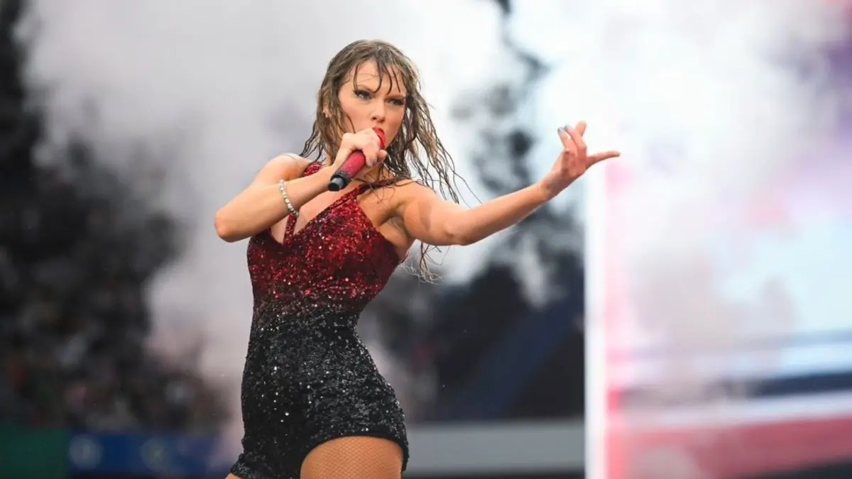 Taylor Swift joyfully interacting with a young girl in the audience.